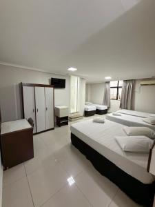 a large bedroom with two beds and a television at Hotel Estação Express in Curitiba