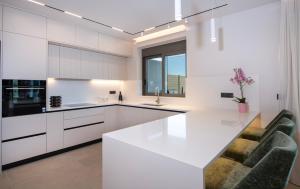 a kitchen with white cabinets and a large white island at Villa Nectar in Kounoupidhianá