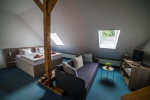 a living room with a bed and a couch at Hotel Churáňov in Stachy +58 photos
