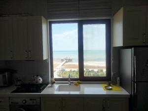 a kitchen with a large window over a sink at sumqayit bulvari deniz kenari in Sumqayıt
