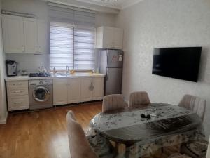 a kitchen with a table and a kitchen with a refrigerator at sumqayit bulvari deniz kenari in Sumqayıt