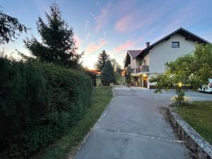 a driveway in front of a house at sunset at Apartma Loško in Cerknica
