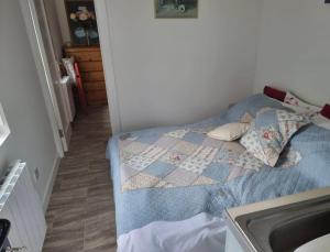 a bedroom with a bed with a quilt on it at Kays Cottage in Galway