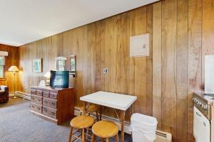 a kitchen with a table and two stools and a tv at King Birch Lake Home, Unit 5 in Alton