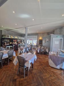 a restaurant with tables and chairs in a room at Hôtel De France in Thann