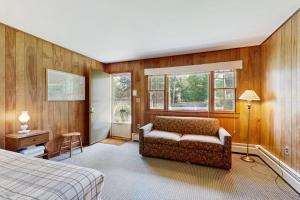 a bedroom with a bed and a couch and windows at King Birch Lake Home, Unit 7 in Alton