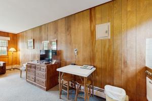a room with a wooden wall with a desk and a television at King Birch Lake Home, Unit 7 in Alton