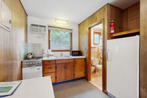 a kitchen with wooden cabinets and a white refrigerator at King Birch Lake Home, Unit 7 in Alton +10 photos