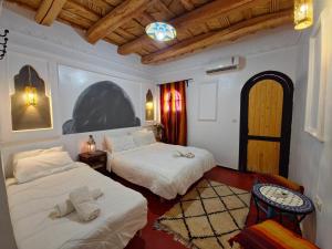a hotel room with two beds and a window at Hotel Atlas Gorge Dades in Boumalne Dades