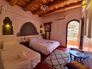 a bedroom with two beds and a window at Hotel Atlas Gorge Dades in Boumalne Dades +11 photos
