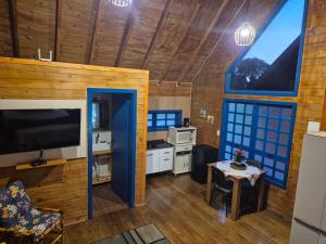 a living room with a large television and a table at Cabanas Laura in São Francisco de Paula