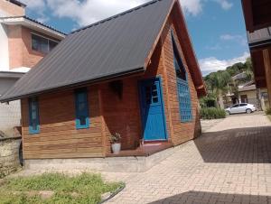 a small wooden building with a blue door at Cabanas Laura in São Francisco de Paula