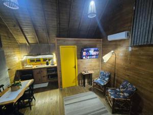 a kitchen with a yellow door and a table and chairs at Cabanas Laura in São Francisco de Paula