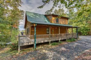 a log cabin in the woods with a green roof at Treetops Hot Tub Fire Pit Pool Table in Copperhill