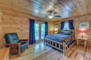 a log cabin bedroom with a bed and a chair at Treetops Hot Tub Fire Pit Pool Table in Copperhill