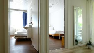 a room with a bedroom with a bed and a mirror at Hotel Frieden in Davos