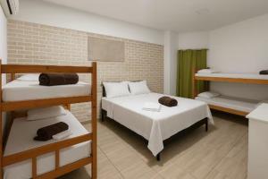 a room with two bunk beds and a brick wall at Pousada Luz do Sol in Penha
