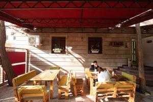 a man and a woman sitting at a table on a patio at Time Stay Hotel in Yerevan