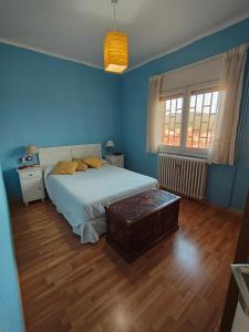 Ein Schlafzimmer mit einem Bett, blauen Wänden und Holzboden in der Unterkunft L'Eixida in Tremp