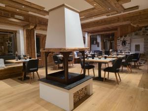 a restaurant with tables and chairs in a room with wooden ceilings at Hotel Maso del Brenta in Caderzone Terme