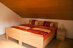 a bed in a room with a wooden ceiling at Haus Heinzmann in Bad Schonborn