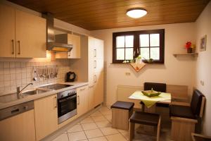 a kitchen with a sink and a table with chairs at Haus Heinzmann in Bad Schonborn