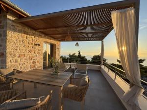 an outdoor patio with a wooden table and chairs at Limestone House in Athani