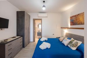 a bedroom with a blue bed with towels on it at Raggio di Sole Ulassai in Ulassai