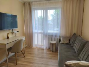 a living room with a couch and a desk at Apartament Kaszmirowy in Gorlice