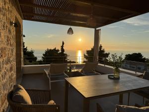 a patio with a table and chairs and the sunset at Limestone House in Athani