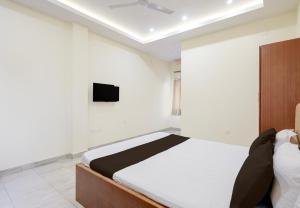 a bedroom with a bed and a tv on the wall at Hotel O Rajdhani Heritage in Nāmkom