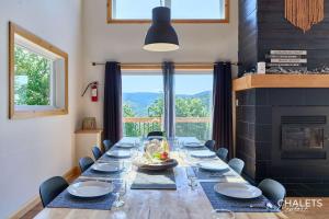 a long table in a room with a large window at Chalet L'Ascension in Saint-Philémon