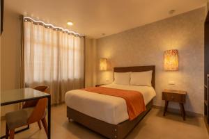 a bedroom with a bed with a desk and a window at Hotel Serra Nova in Cajamarca +46 photos