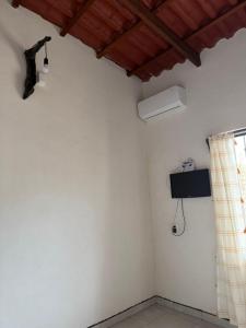 a room with a white wall with a fan and a window at Casa ciruelo in Las Varas