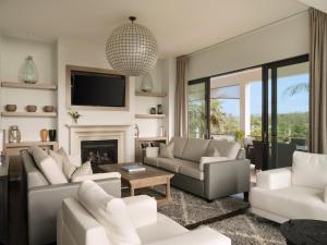 a living room with white furniture and a fireplace at The Loren at Pink Beach in Tuckerʼs Town