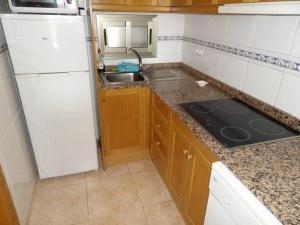 cocina con nevera blanca y fregadero en Bali Apartamento en Benidorm