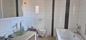 a bathroom with a sink and a tub and a toilet at Lindenplatz 6 in Sondershausen