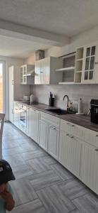 a kitchen with white cabinets and a wooden floor at Lindenplatz 6 in Sondershausen +15 photos