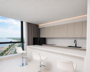 a kitchen with white counter chairs and a large window at Atlantic Suites Hotel in Georgetown