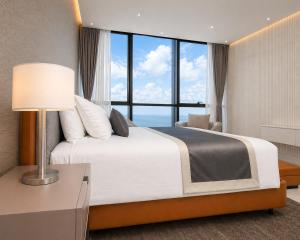 a bedroom with a large bed with a large window at Atlantic Suites Hotel in Georgetown