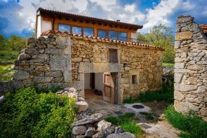 an old stone house with a balcony on top of it at Jaricha in Cabezas Altas