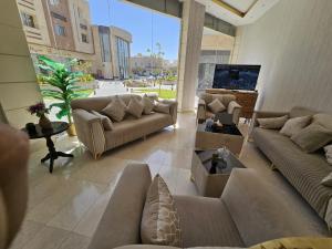 a living room with couches and a large window at فندق نواة العزيزية in Medina
