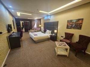 a large hotel room with a bed and chairs at فندق نواة العزيزية in Medina +79 photos