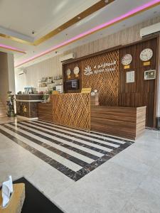 a restaurant with a counter with clocks on the wall at فندق نواة العزيزية in Medina