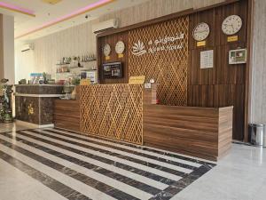 a restaurant with clocks on the wall and a counter at فندق نواة العزيزية in Medina