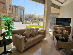 a living room with a couch and a flat screen tv at فندق نواة العزيزية in Medina