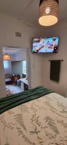 a bedroom with a bed and a flat screen tv at Hope's Harvest Nook in Montagu