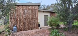 a small house with a wooden fence on the side of it at Hope's Harvest Nook in Montagu