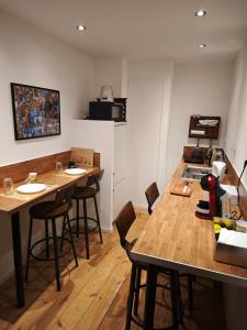 a kitchen with wooden tables and chairs in a room at La chambre de pousse in Boulogne-sur-Mer