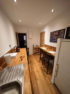 a kitchen with a sink and a table and a refrigerator at La chambre de pousse in Boulogne-sur-Mer +5 photos